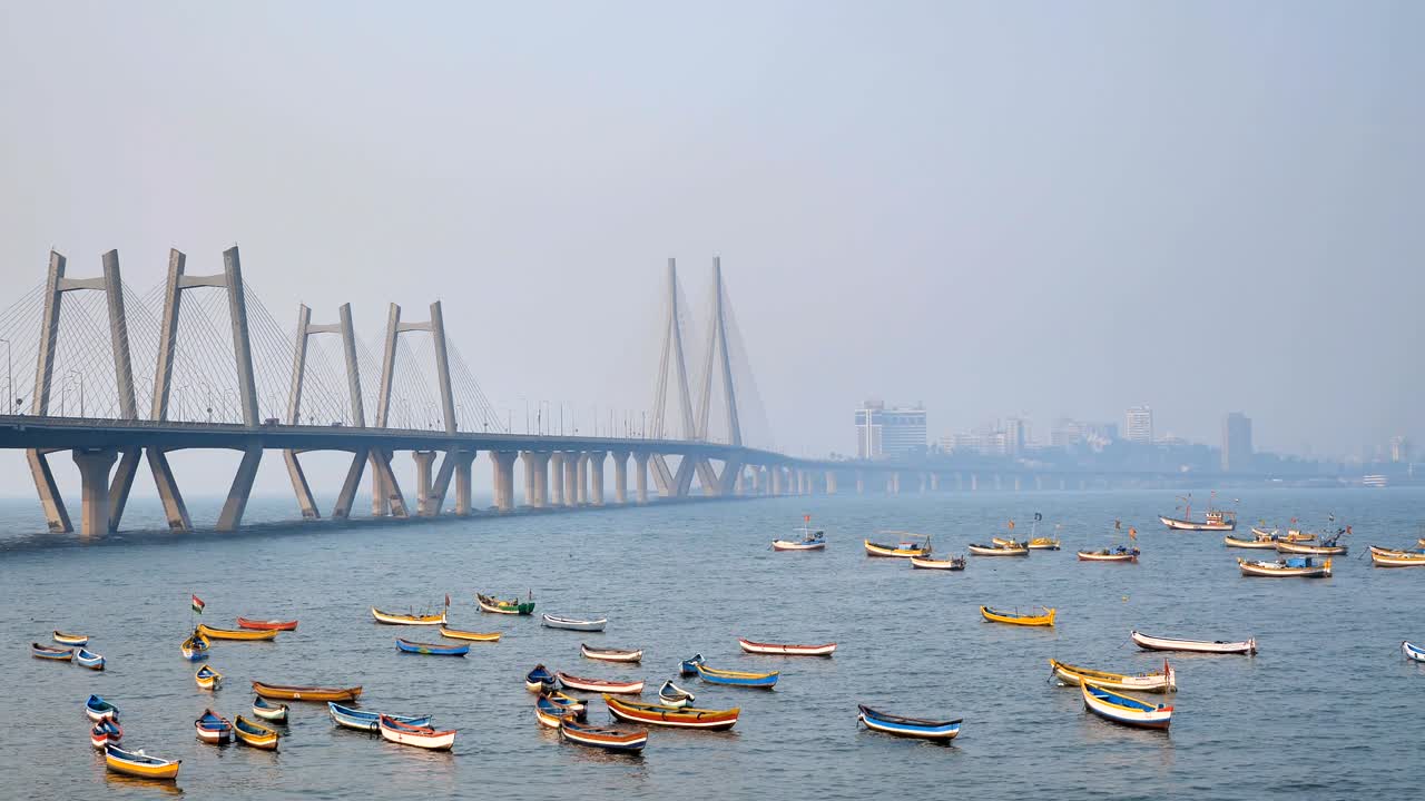 los coloridos barcos de pesca están estacionados bajo el moderno puente de cable satyed