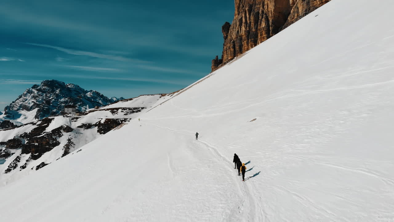 Vista aerea di escursionisti in un vasto paesaggio montano innevato