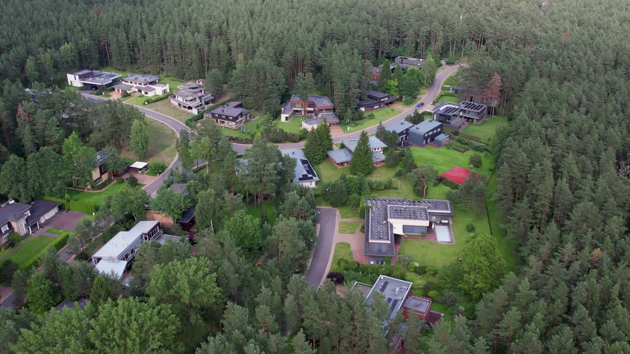 A rotating aerial view of Lauru kvartalas showing modern forest-edge homes, winding roads, and dense tree canopy, ideal for stories on eco-district planning and sustainable residential design