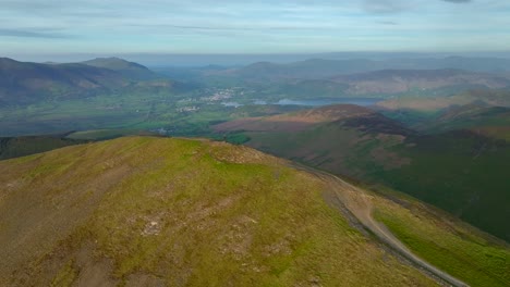 Distant-lone-hiker-on-rounded-mountain-summit-at-golden-hour