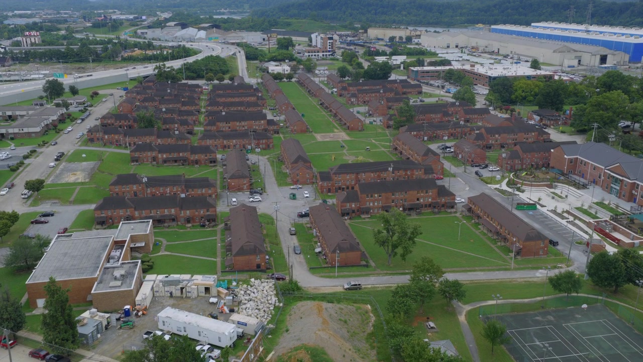 Vista aerea di file di case a schiera in mattoni e un campo da tennis in un quartiere di Chattanooga, Tennessee, con lavori di costruzione in corso nelle vicinanze