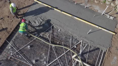 construction workers in africa pour concrete floor pad for new home