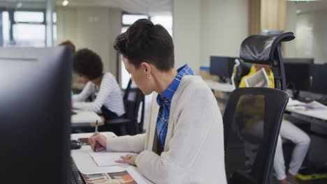 Porträt-Einer-Kaukasischen-Kreativen-Geschäftsfrau,-Die-Am-Schreibtisch-In-Einem-Modernen-Büro-Schreibt