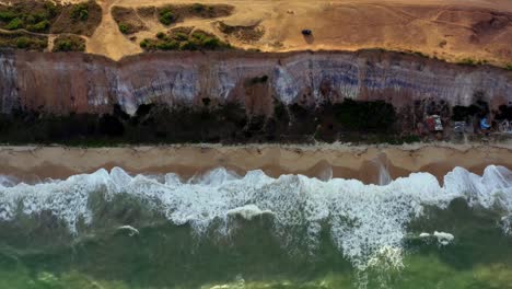 Beautiful-rising-aerial-drone-shot-of-a-gorgeous-cliff-above-a-tropical-beach-below-in-Praia-do-Sol-near-Joao-Pessoa,-Brazil-on-a-warm-summer-day