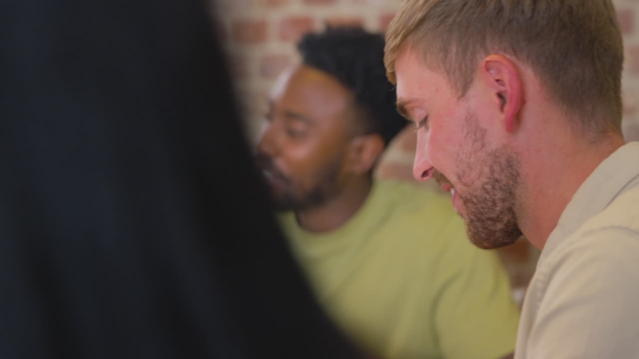 grupo multicultural de amigos sentados alrededor de la mesa y hablando en casa fiesta de cena juntos