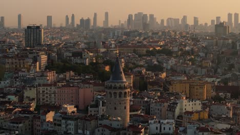 galata tower during colorful sunrise, istanbul turkey. skyscrapers in background