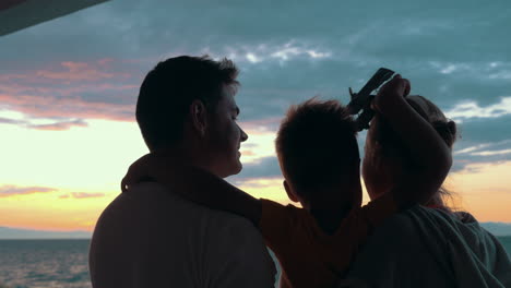 Familia-Feliz-Con-Niño-Disfrutando-Del-Atardecer