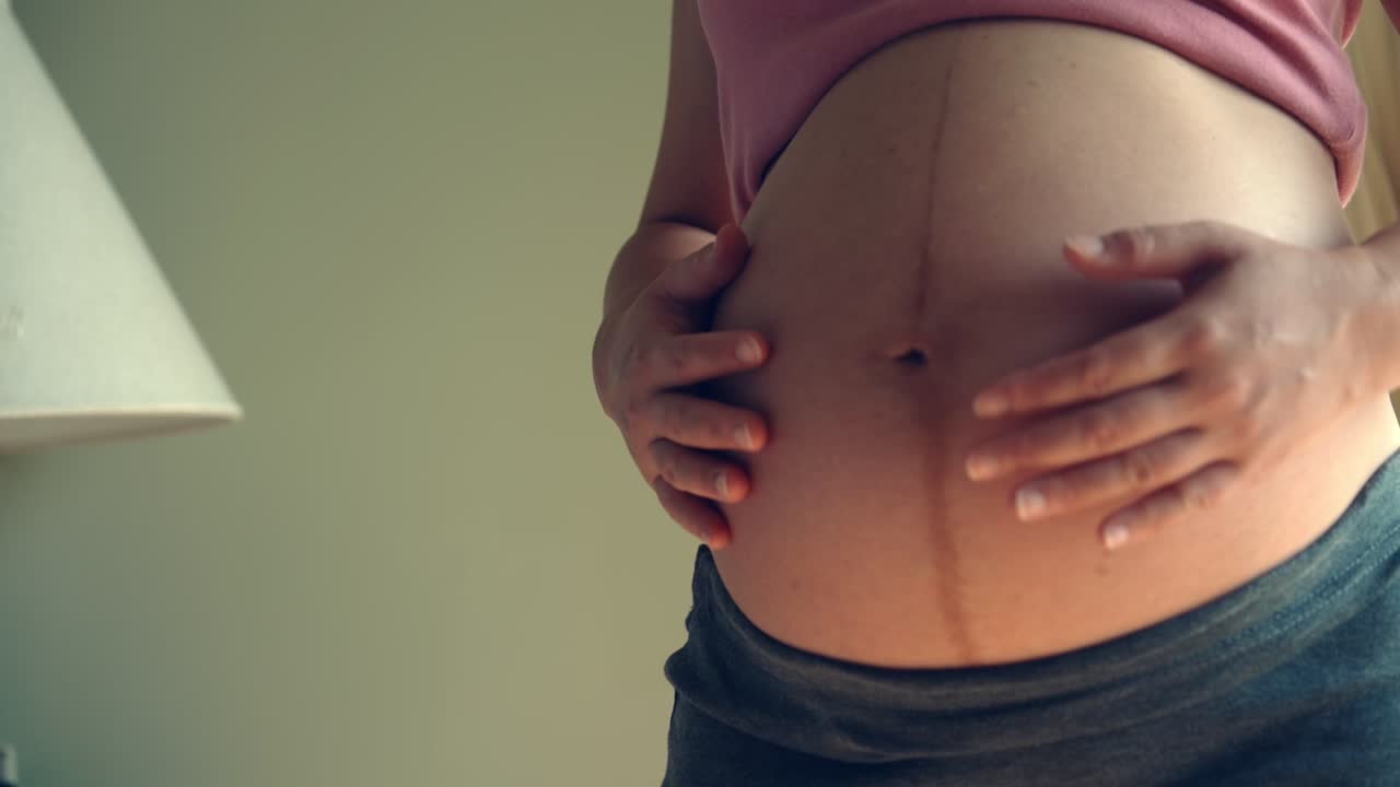 mujer embarazada feliz y esperando un bebé en casa.
