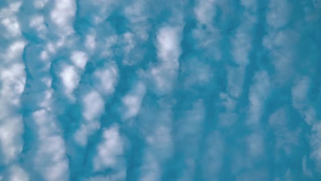 un lapso de tiempo cinematográfico desde abajo, surfando nubes blancas, cielo azul, sol diurno, video estático 4k