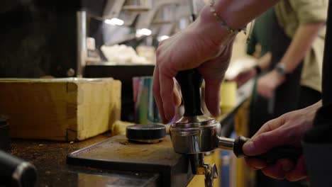 the barista at the coffee machine prepares the coffee for brewing