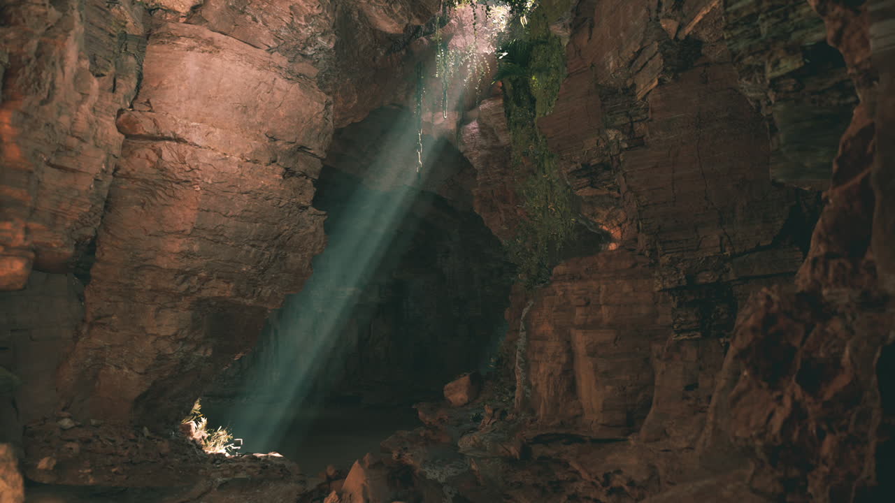 rayos de luz iluminando una caverna tranquila con paredes rocosas en un paisaje natural