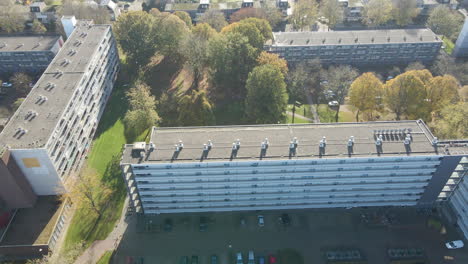 Jib-down-of-social-housing-flat-with-parking-lot-and-green-park-in-autumn