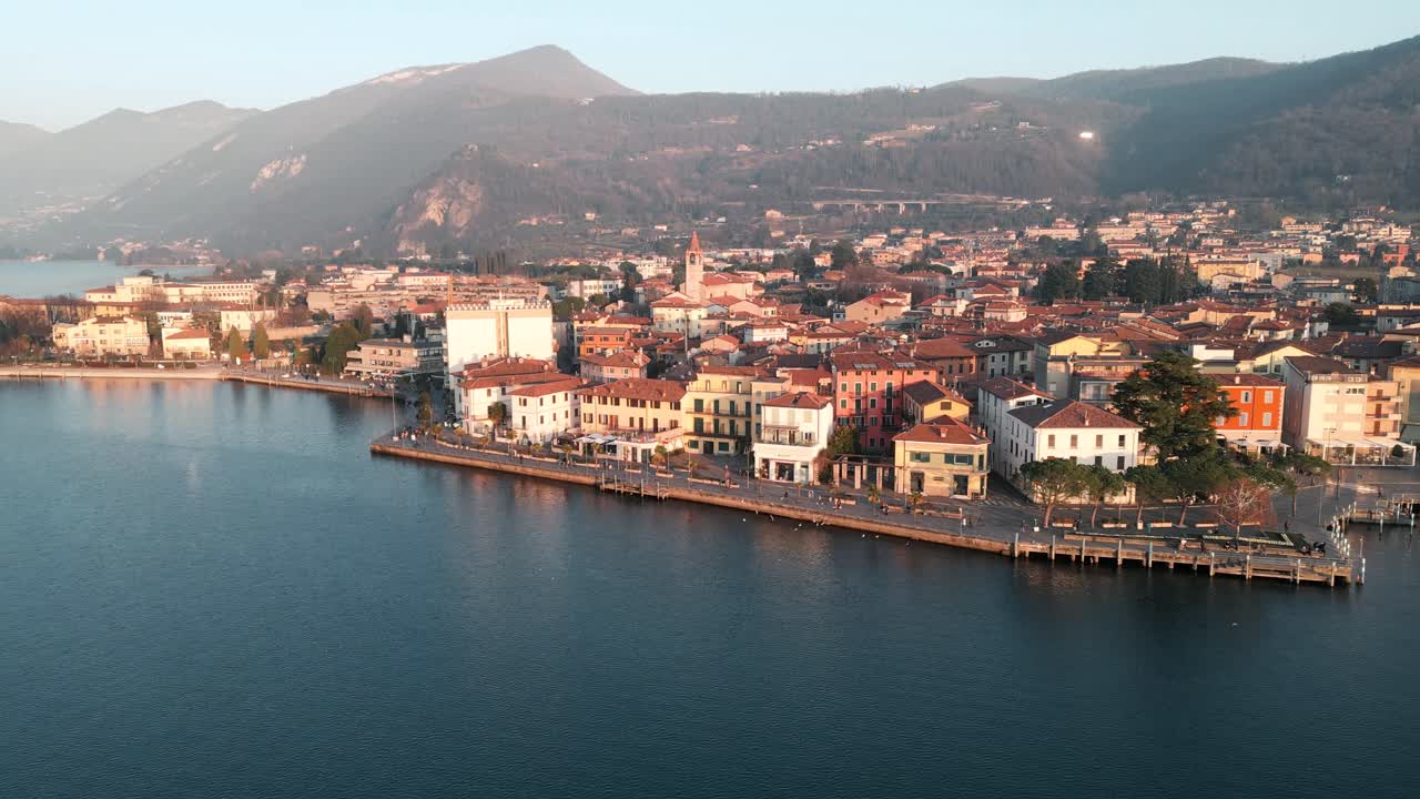 Aerial view city Iseo in Italy. Small town on Iseo Lake, tourist destination in Italian north in the mountains Alps. Drone flight on lake shore harbor with small town background