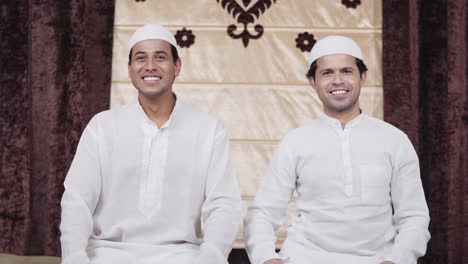 two muslim men looking and smiling at the camera