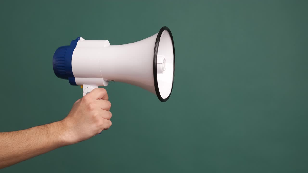 Young male hand holding a white megaphone