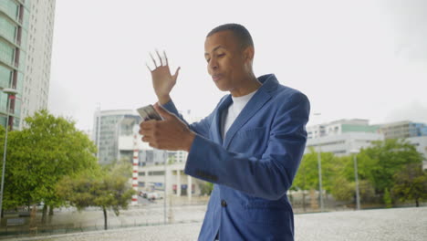 successful young man reading good news from smartphone.