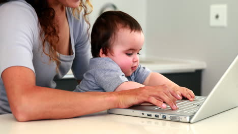 Mutter-Sitzt-Mit-Baby-Auf-Dem-Schoß-Und-Benutzt-Den-Laptop