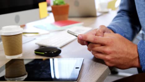 Businessman-using-mobile-phone-at-desk