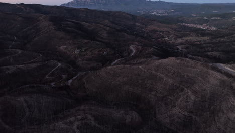 Twilight-aerial-view-over-hillside-burned-remains-of-forest-fire-natural-disaster