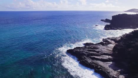 Drohnenaufnahmen-Von-Den-Hawaii-Inseln-Mit-Klarem,-Blauem-Meer-Und-Weißen-Schaumkronen-An-Den-Felsklippen-An-Einem-Wunderschönen-Sonnigen-Tag-Auf-Oahu-In-Der-Waimanlao-Bucht