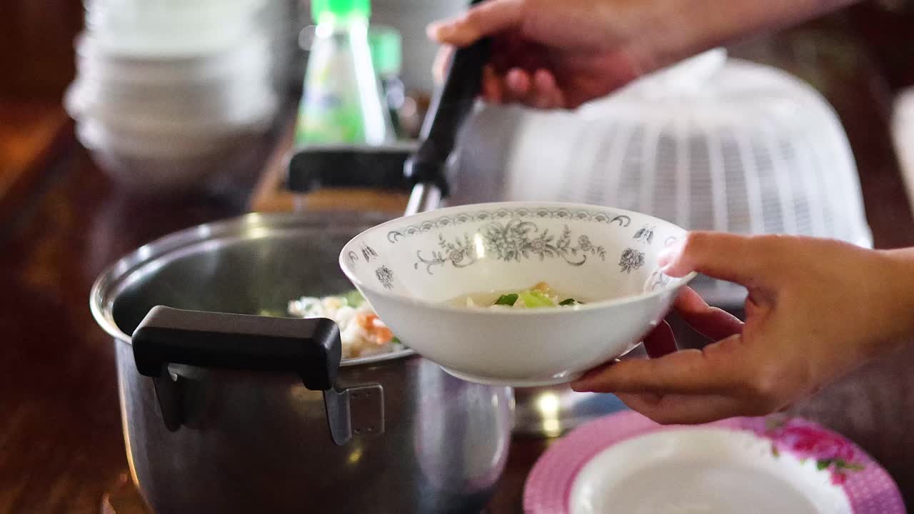 persona que sirve arroz hervido en un cuenco