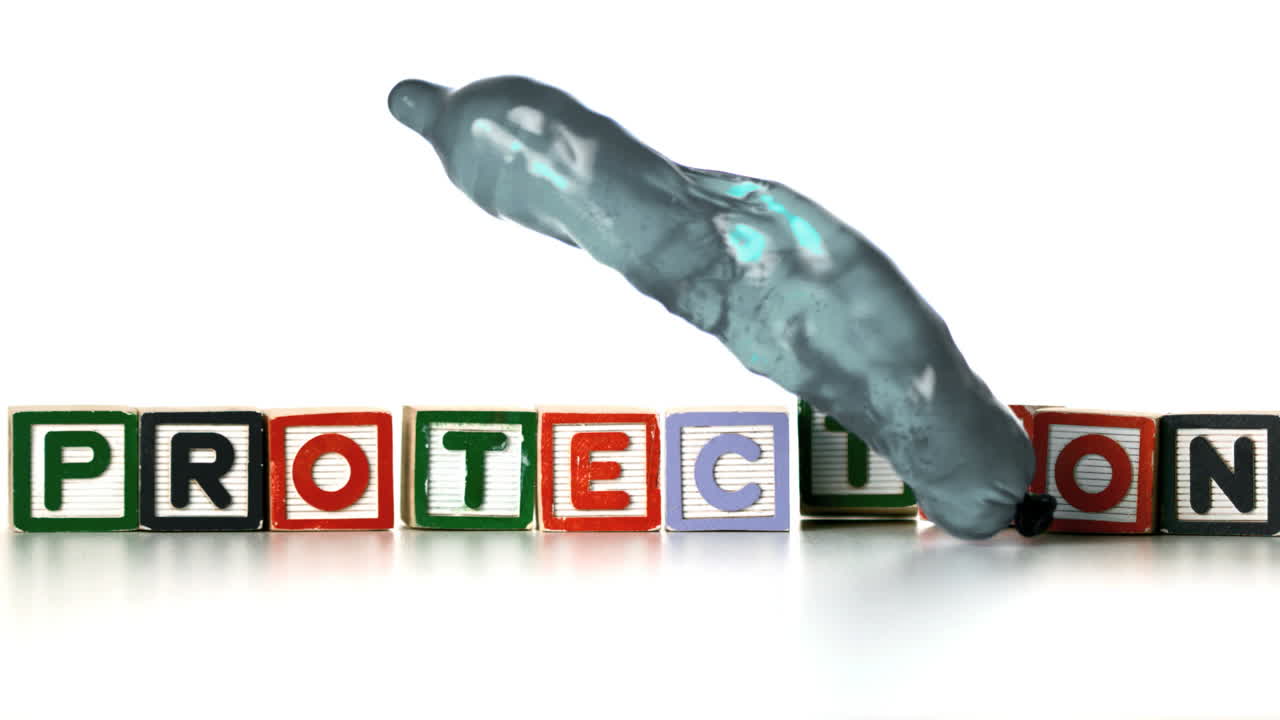 condón lleno de agua cayendo y rebotando delante de los bloques de protección ortográfica