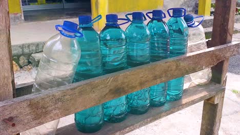 cierre de botellas de agua de plástico llenas de gasolina para la venta en un quiosco en la carretera en el campo rural de timor-leste