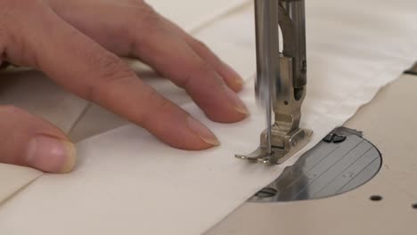 close-up on hand of woman working with sewing machine