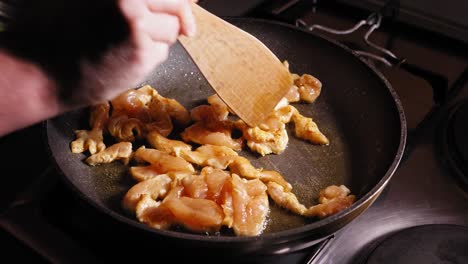 Freír-Pollo-En-Una-Sartén,-Revolviendo-Con-Una-Cuchara-De-Madera,-Comida-Japonesa