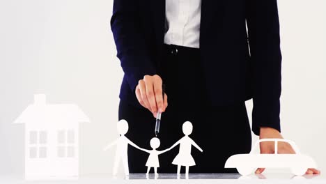 mujer de negocios señalando un papel cortado de la familia