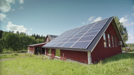 time lapse of clouds in sky over solar panel covered barn in countryside