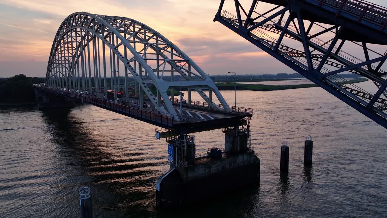 노드 강을 가로지르는 강철 다리가 멀리 해가 지는 것처럼 내려오고 있습니다.