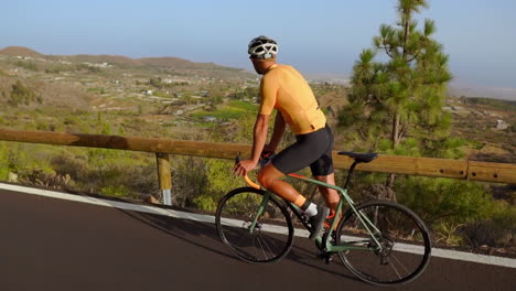 Un-Ciclista-En-Bicicleta-De-Carretera,-Un-Hombre-Disfruta-Del-Ejercicio-Al-Aire-Libre-En-Una-Tranquila-Carretera-Matutina.-La-Representación-En-Cámara-Lenta-Magnifica-La-Experiencia-De-Los-Deportes-Extremos.