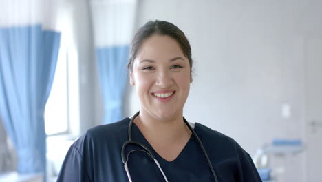 portrait of happy caucasian female doctor smiling in hospital ward, slow motion