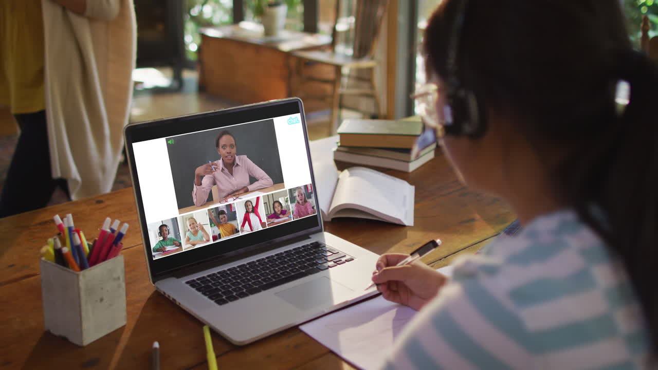estudiante que usa una computadora portátil para una lección en línea en casa, con un maestro y una clase diversos en la pantalla
