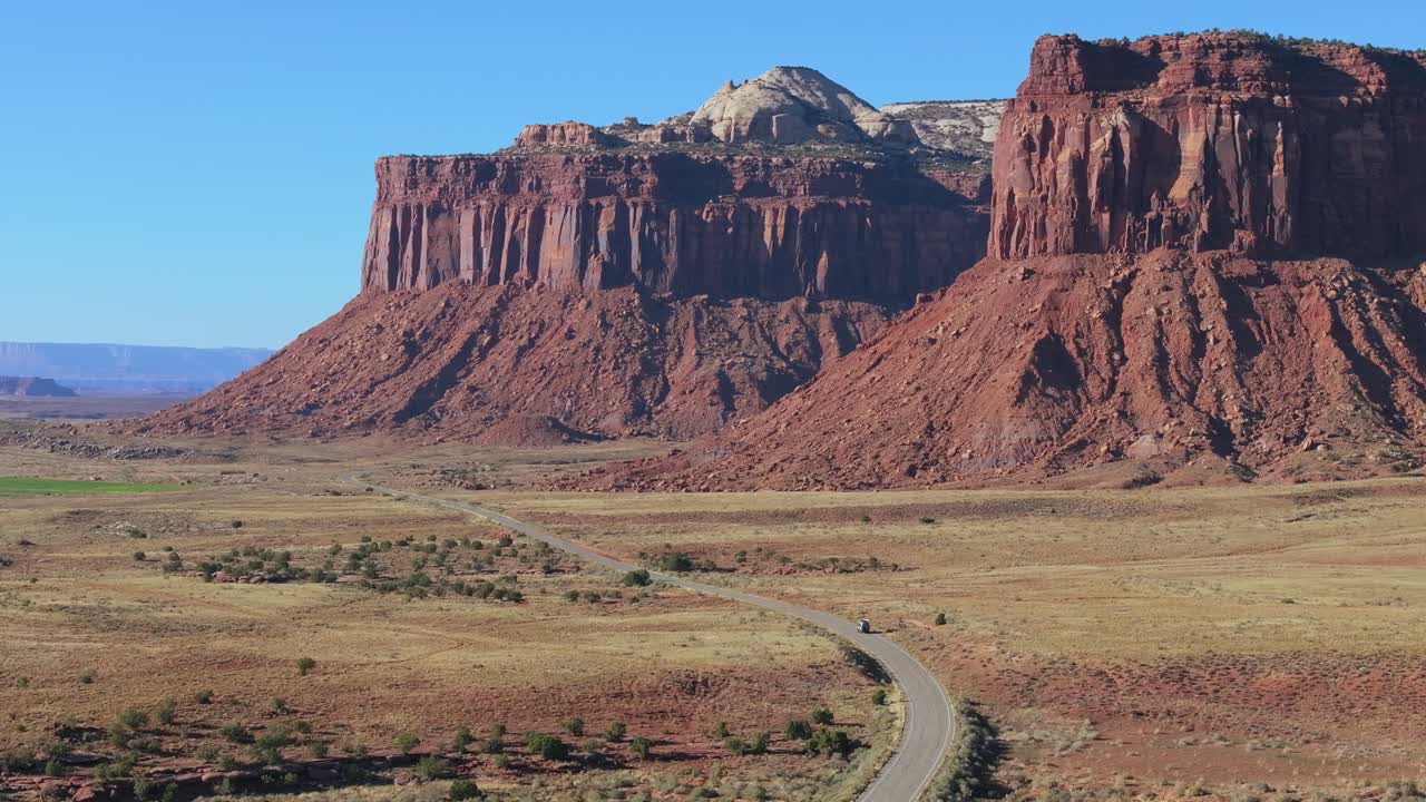 Scenic road through Moab's red rock desert, Indian Creek, under blue sky