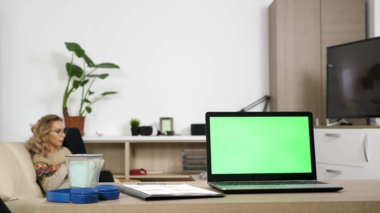 Office scene with a laptop featuring a green screen