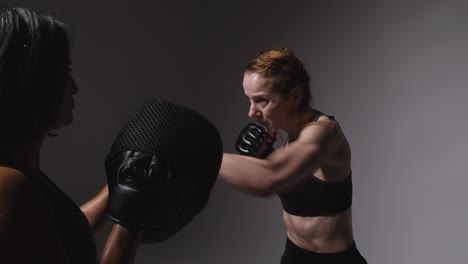 Studioaufnahme-Von-Zwei-Reifen-Frauen-In-Fitnesskleidung,-Die-Gemeinsam-Boxen-Und-Sparring-Trainieren-2