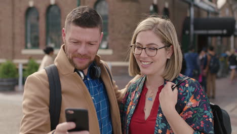 portrait of smiling happy couple embrace posing taking selfie photo using smartphone in city