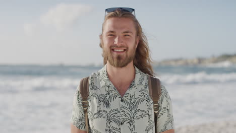 Retrato-De-Un-Joven-Atractivo-Sonriendo-Feliz-En-La-Playa-Disfrutando-De-Un-Cálido-Día-De-Vacaciones-De-Verano-En-La-Playa-Mirando-La-Cámara