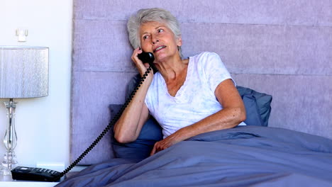 Mujer-En-La-Cama-Hablando-Por-Teléfono