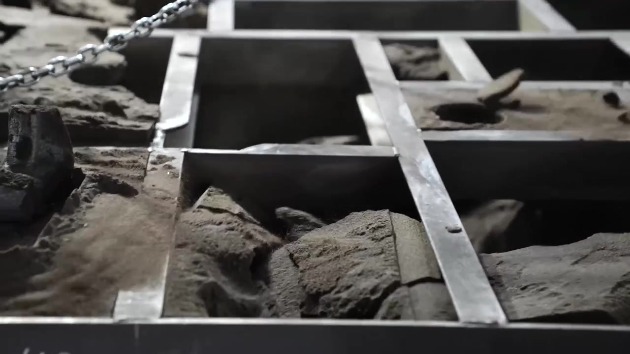 Overhead view of a sand casting mold flask grid filled with cores in a foundry