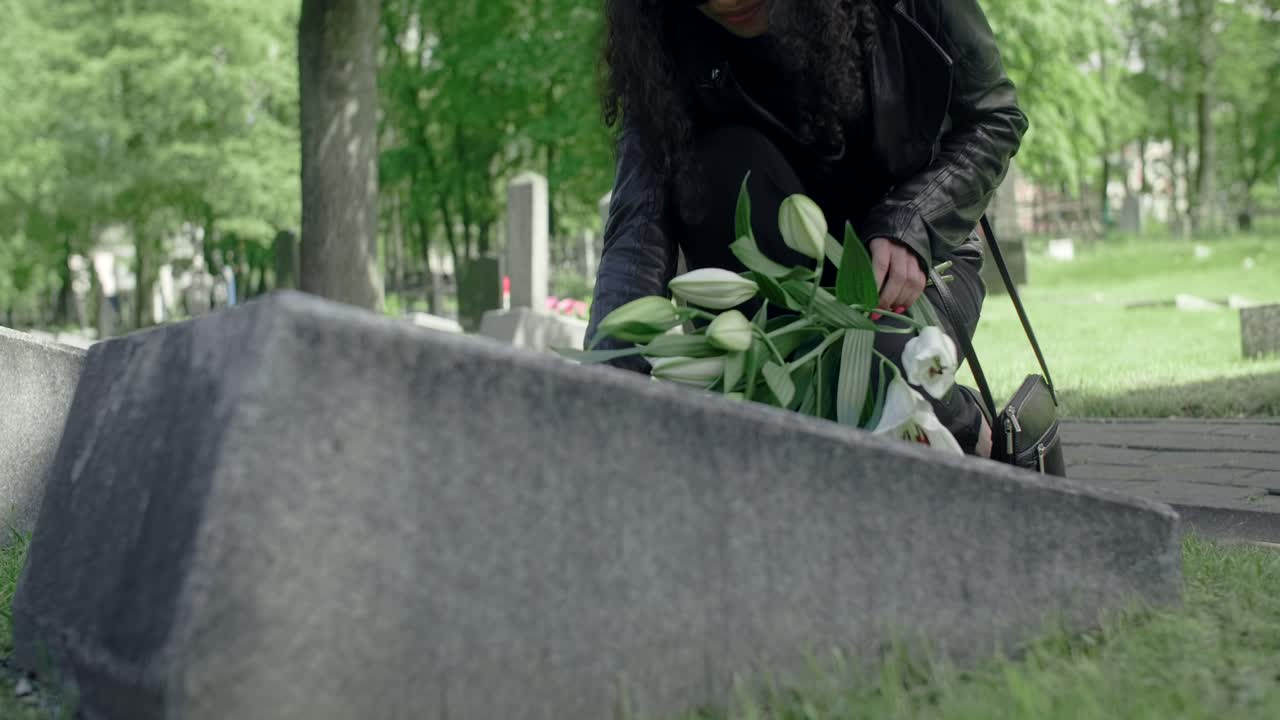 Woman Paying Respects at a Cemetery