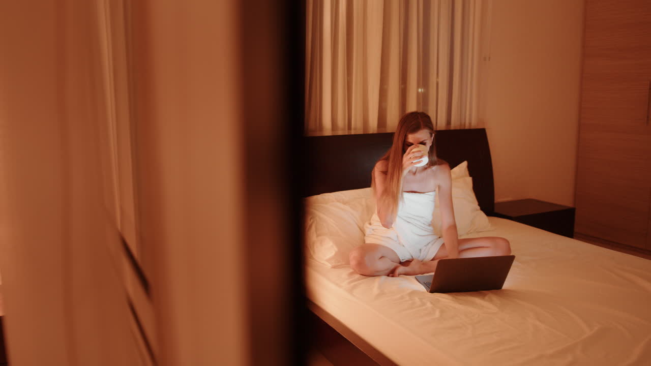 женщина работает на ноутбуке в постели ночью