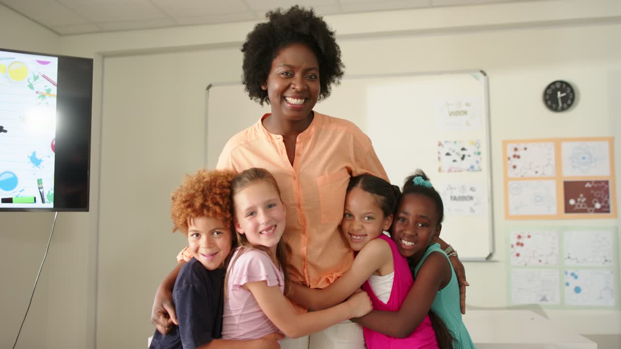 African American teacher with four school kids moving in, hugging whiteboard celebrating at school