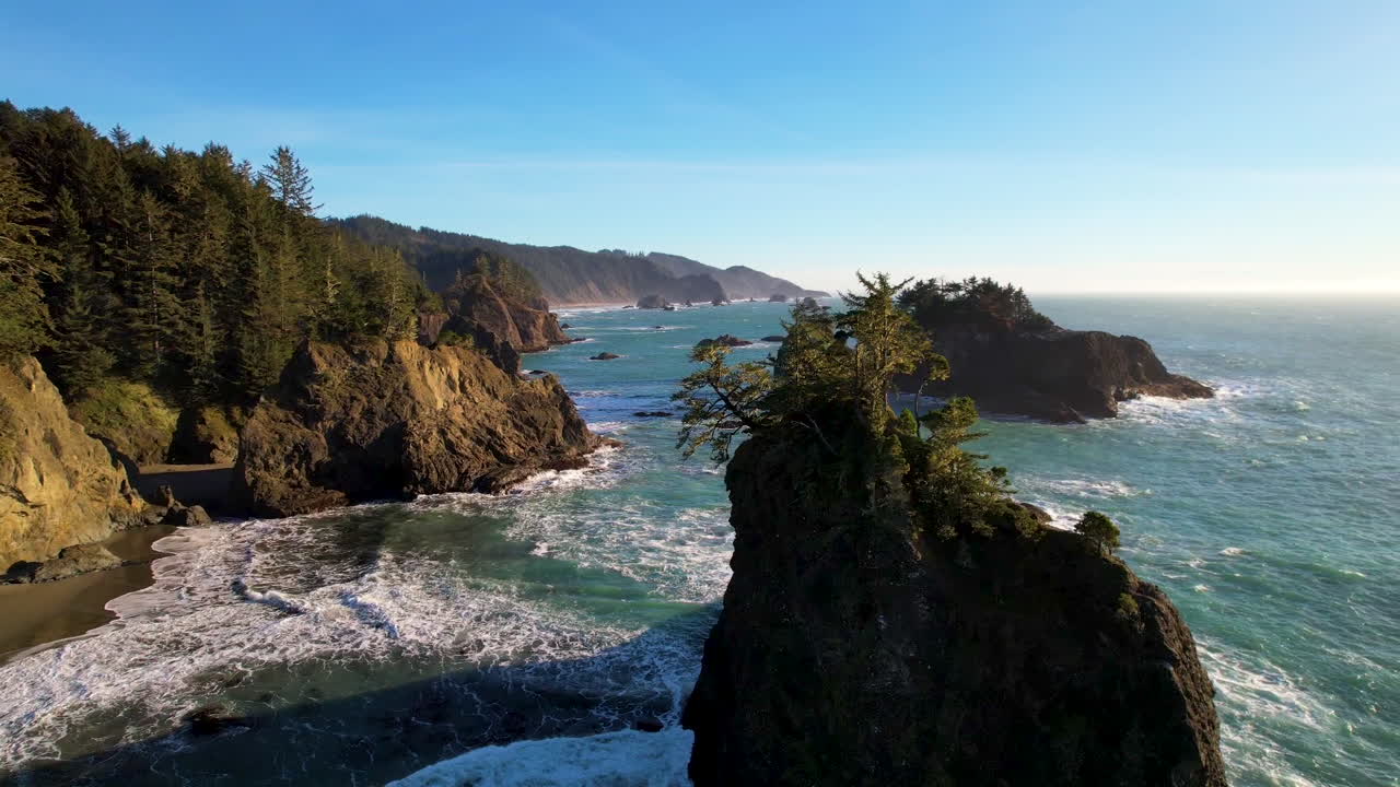 Drone rotating around a sea stack with ocean cliffside in the distance.