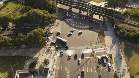 inclinación aérea hacia abajo sobre el cruce con el tráfico, los automóviles y el cruce de autobuses durante la hora dorada en buenos aires
