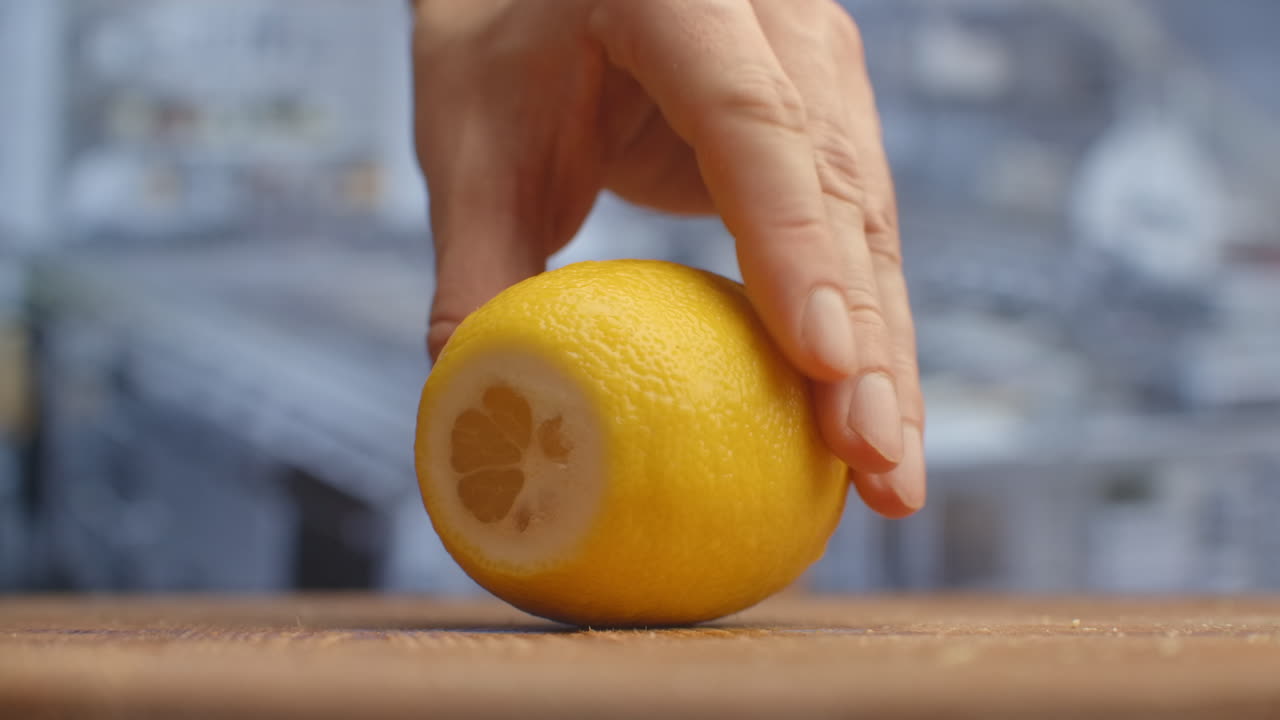 Cut with a knife on a wooden board close-up of a lemon in the kitchen. shred