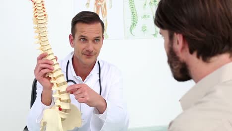 Doctor-showing-his-patient-a-spine-model