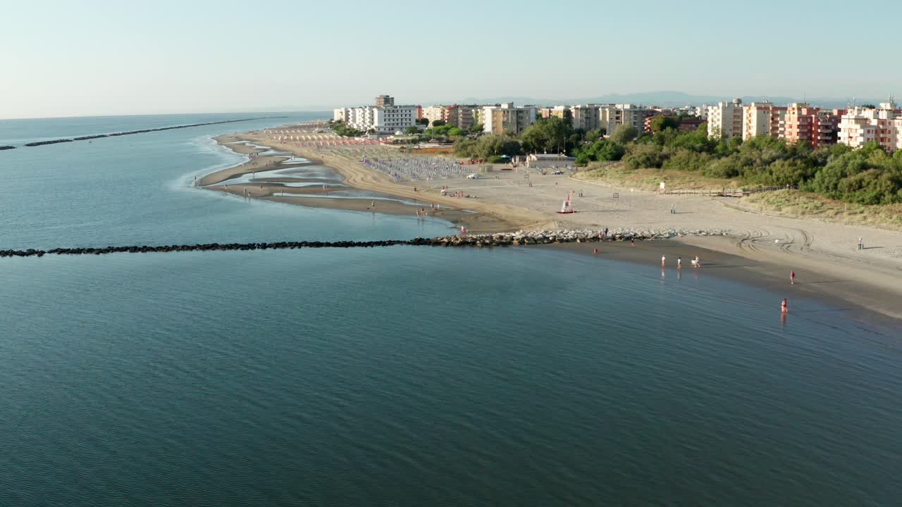 toma aérea de playa de arena con sombrillas, típica costa adriática